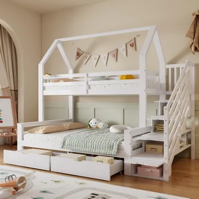 A white bunk bed with a house-shaped frame, decorated with a banner of flags. It has stairs with storage compartments and drawers underneath the bottom bed.