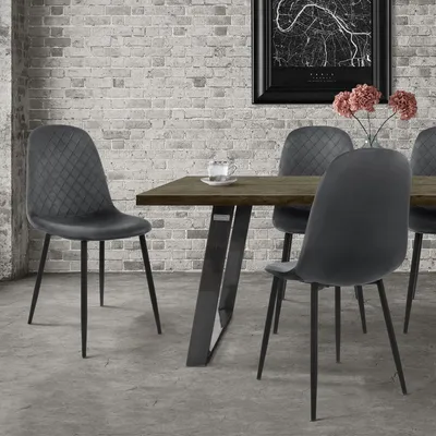 A dining set with chairs around a table, in front of a brick wall.