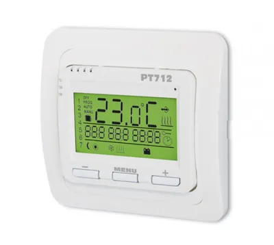 A white digital thermostat mounted on a white wall.