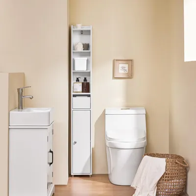 A bathroom scene with a sink, toilet, and a tall, narrow storage cabinet.