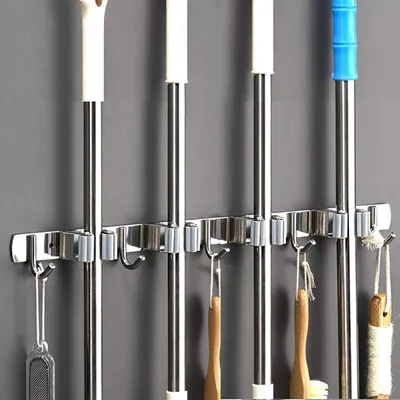 A wall-mounted organizer for cleaning tools like mops and brooms.
