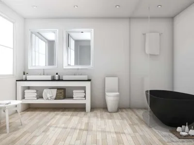A modern, minimalist bathroom with a double vanity, toilet, and a black bathtub.