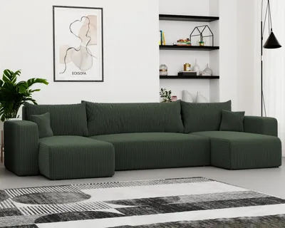 A large green sectional sofa is shown in a living room setting with shelves and artwork in the background.