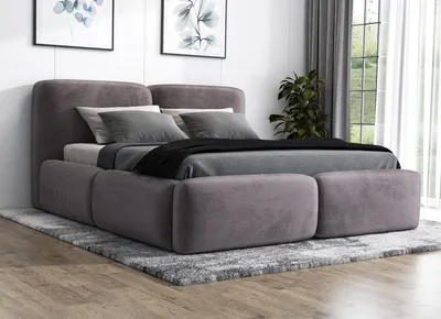 A modern, upholstered bed with a gray fabric finish is shown in a bedroom setting.