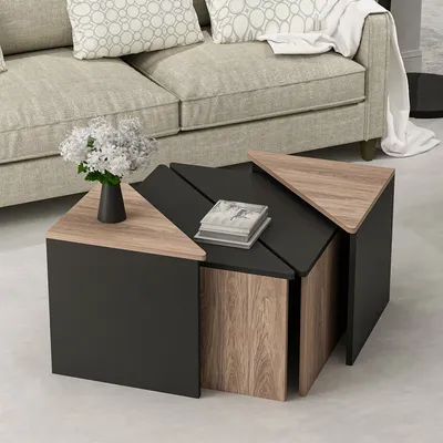 A modern living room with a couch and a set of triangular coffee tables.