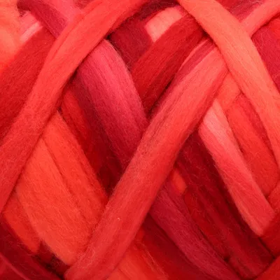 A close-up view of thick, braided yarn in various shades of red, orange, and pink.