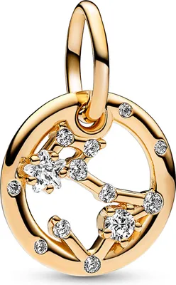 A close-up studio shot of a gold charm with clear stones.