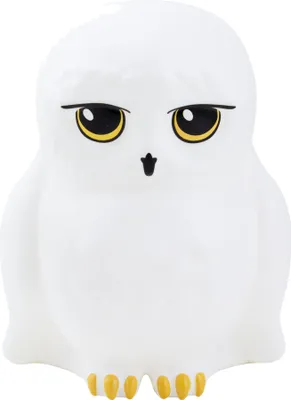 A white owl figurine with yellow eyes and feet against a white background.
