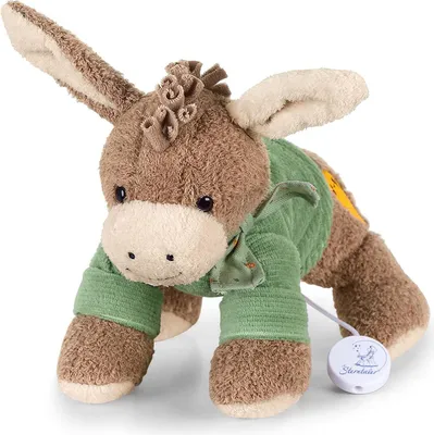 A plush toy donkey with a green sweater and a music box attached.