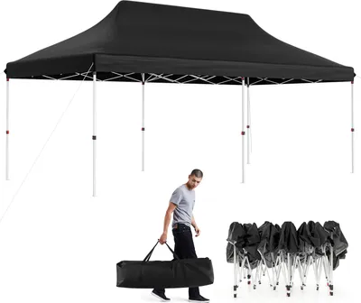 A man carries a folded canopy in a bag next to a set-up canopy.