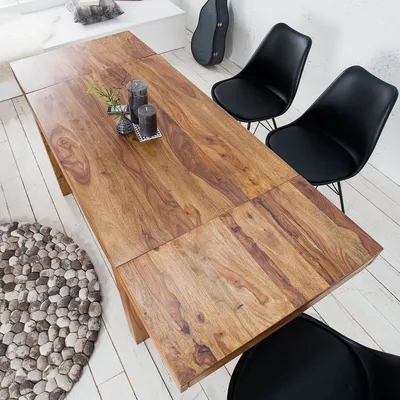 A wooden dining table with chairs in a room.