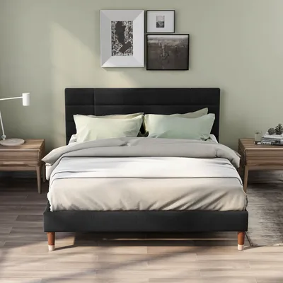 A bedroom scene featuring a black upholstered bed with light green pillows and gray bedding.