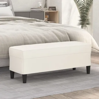 A creme-colored bench is placed in front of a bed in a bedroom setting.
