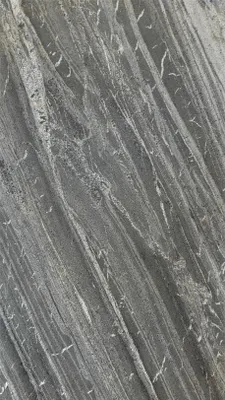 A close-up view of a stone veneer with a dark gray base and lighter gray and white veining.