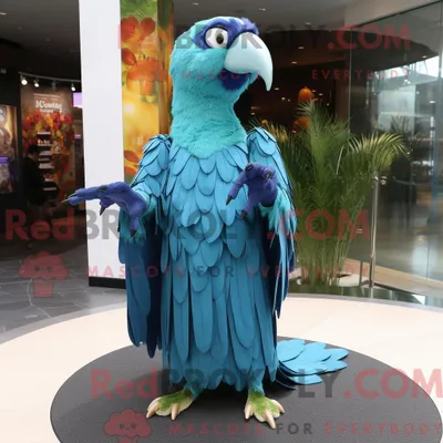 Produktbild von Maskottchenfigur REDBROKOLY eines türkisfarbenen Papageis mit Kleid und Schalnadeln