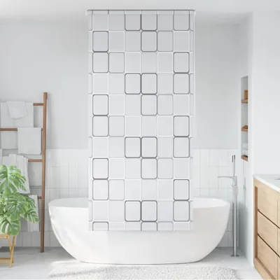 A modern bathroom with a white bathtub and a white shower curtain with a square pattern.