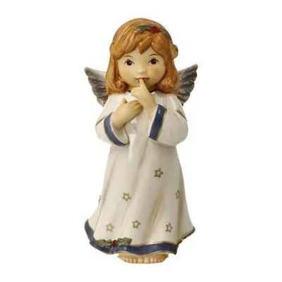 A ceramic angel figurine with wings, dressed in a white robe adorned with stars and blue trim. The angel has its finger to its lips, as if signaling for silence.