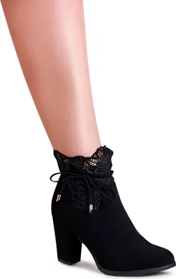 A close-up shot of a woman's lower leg wearing a black ankle boot.