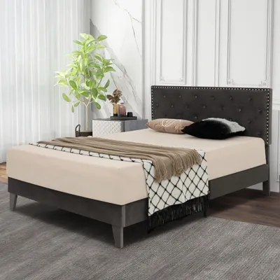 A bedroom scene with a bed, nightstand, and plant.