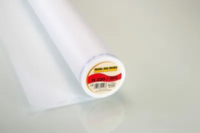 A roll of white interfacing is shown on a reflective surface.