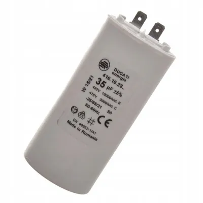 A white capacitor with text and symbols printed on it, resting on a white background.