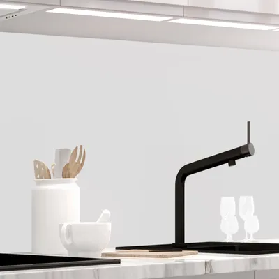 A kitchen counter with various items including a faucet, glasses, and kitchen utensils.