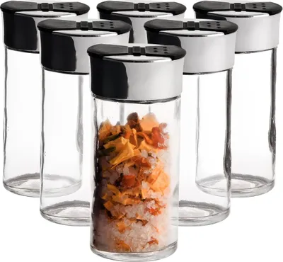 A group of spice jars with one jar filled with spices.