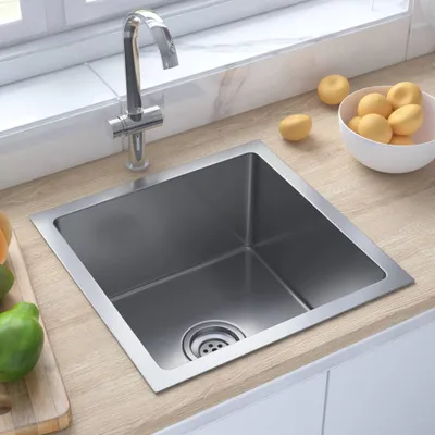 A stainless steel kitchen sink with a faucet, set on a wooden countertop next to a window.