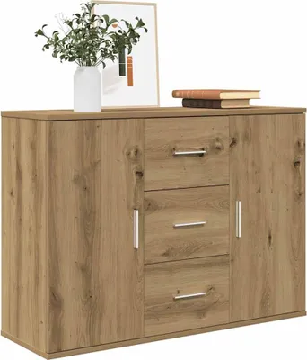 A wooden sideboard with three drawers and two doors, decorated with a vase of plants and books on top.