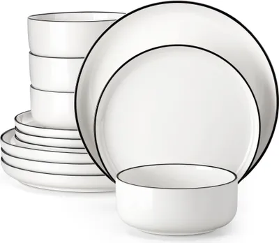 A stack of white ceramic plates and bowls with a thin black rim, arranged on a white background.