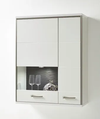 A modern white wall unit with glass doors and drawers, displaying decorative items.