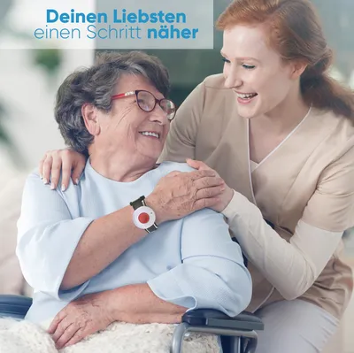 A caregiver assisting an elderly woman in a wheelchair, with a focus on a medical alert device on the woman's wrist.
