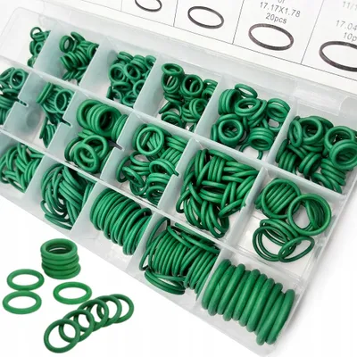 A clear, well-lit overhead view of a plastic organizer box filled with green O-rings of various sizes.