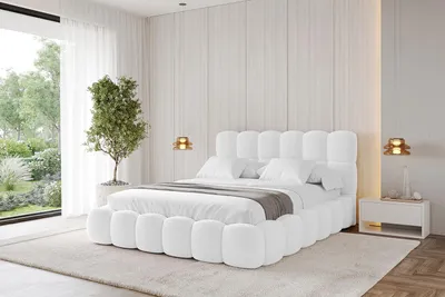 A modern bedroom with a white upholstered bed.