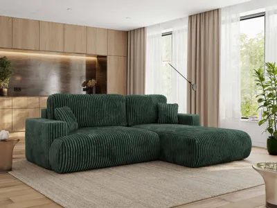 A green corduroy sectional sofa in a modern living room with wooden cabinets and sheer curtains.