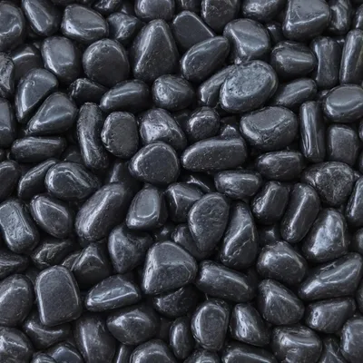Schwarze Kieselsteine mit nasser glänzender Oberfläche nah aufgenommen