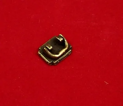 Produktbild von Mini-Möbelgriff  aus Metall. Für Puppenstuben. Antikpatinirt. 1,2x0,9 cm.
