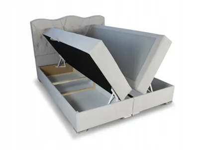 A storage bed with its mattress and base lifted to reveal the storage compartment.