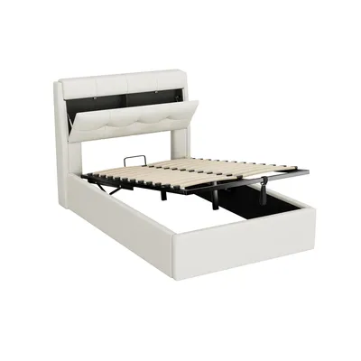 A white upholstered bed frame with the mattress support mechanism raised, revealing storage space underneath. The headboard has a lift-up compartment.