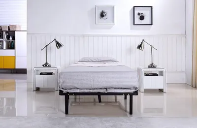 A bedroom scene with a bed, nightstands, and lamps.
