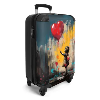 A suitcase with a graffiti-style image of a girl holding a red balloon.