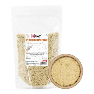 A bag of nutritional yeast flakes next to a wooden bowl filled with the same product.