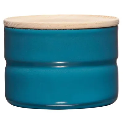A teal ceramic storage jar with a wooden lid.