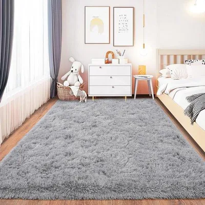 Imagen del producto de Alfombra Unyqoos® de pelo alto, color gris, fabricada con poliéster suave y espuma viscoelástica, con base de silicona antideslizante, ideal para salones, dormitorios y habitaciones infantiles