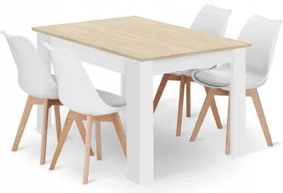 A white dining table with a light wood top and four white chairs with wooden legs.