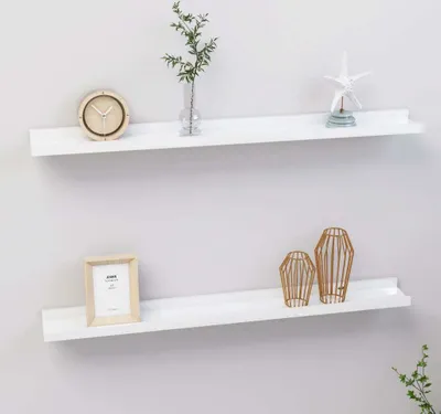 Two white shelves mounted on a light gray wall, each displaying decorative items.