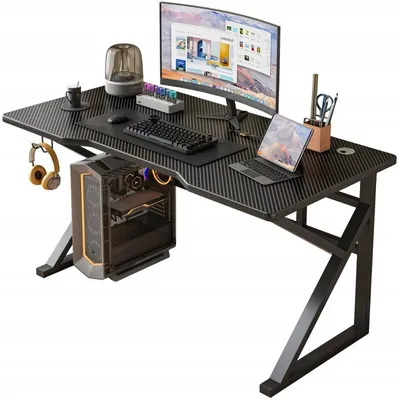 A gaming desk setup with a computer, monitor, laptop, and accessories.