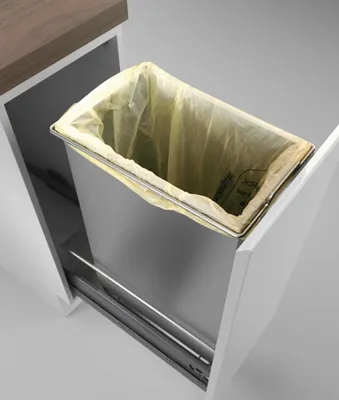 A trash bin with a yellow bag inside, pulled out from a cabinet.