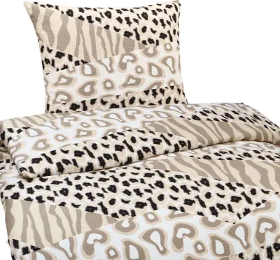 A close-up view of a bedding set with a patchwork animal print design.