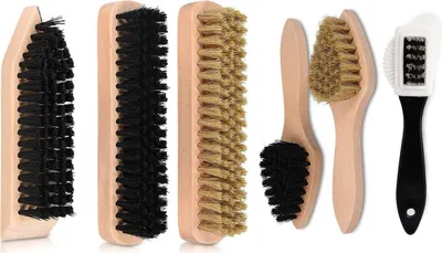 A collection of shoe cleaning brushes and a polishing cloth arranged on a white background.